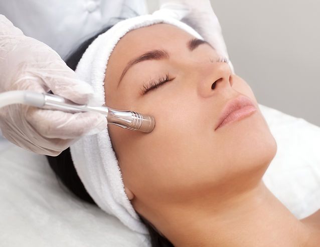 A Woman is Getting a Dermapen Treatment on Her Forehead — Aura Mediclinic in Ashmore, QLD