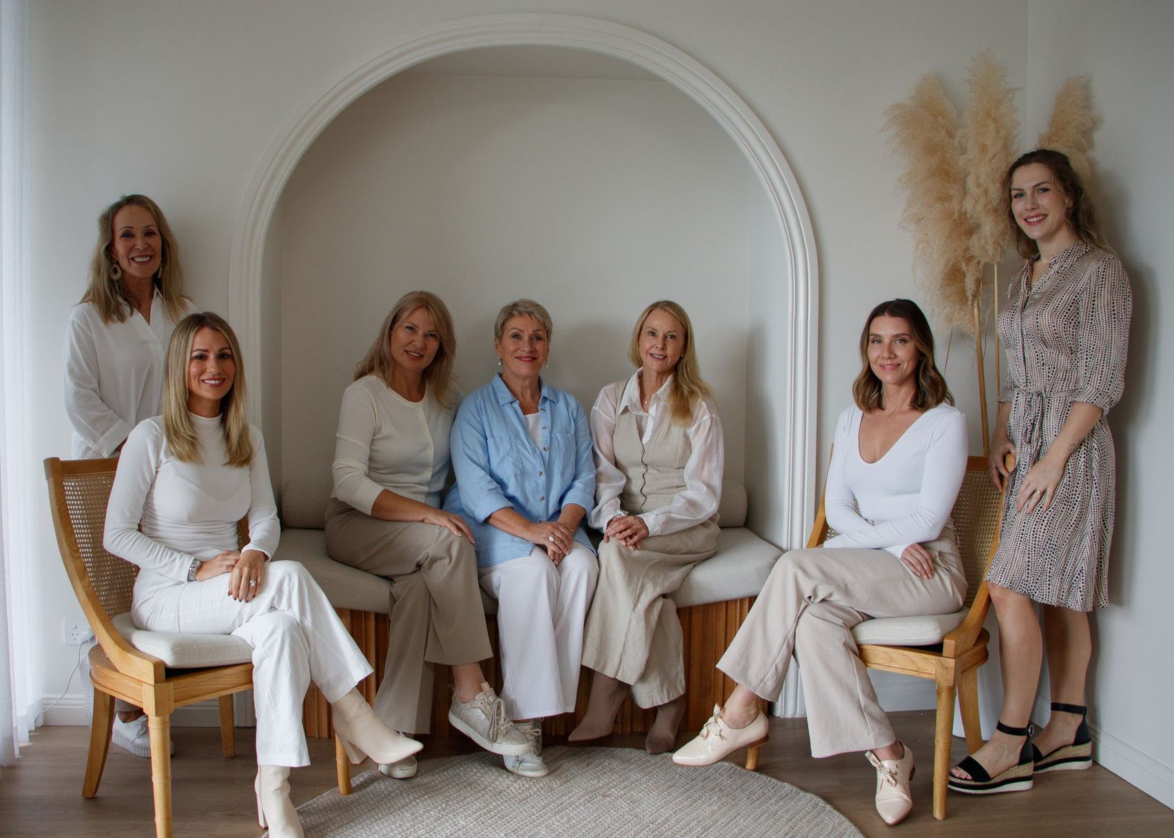 A Woman With Blonde Hair is Smiling and Holding Her Hand to Her Face — Aura Mediclinic in Ashmore, QLD