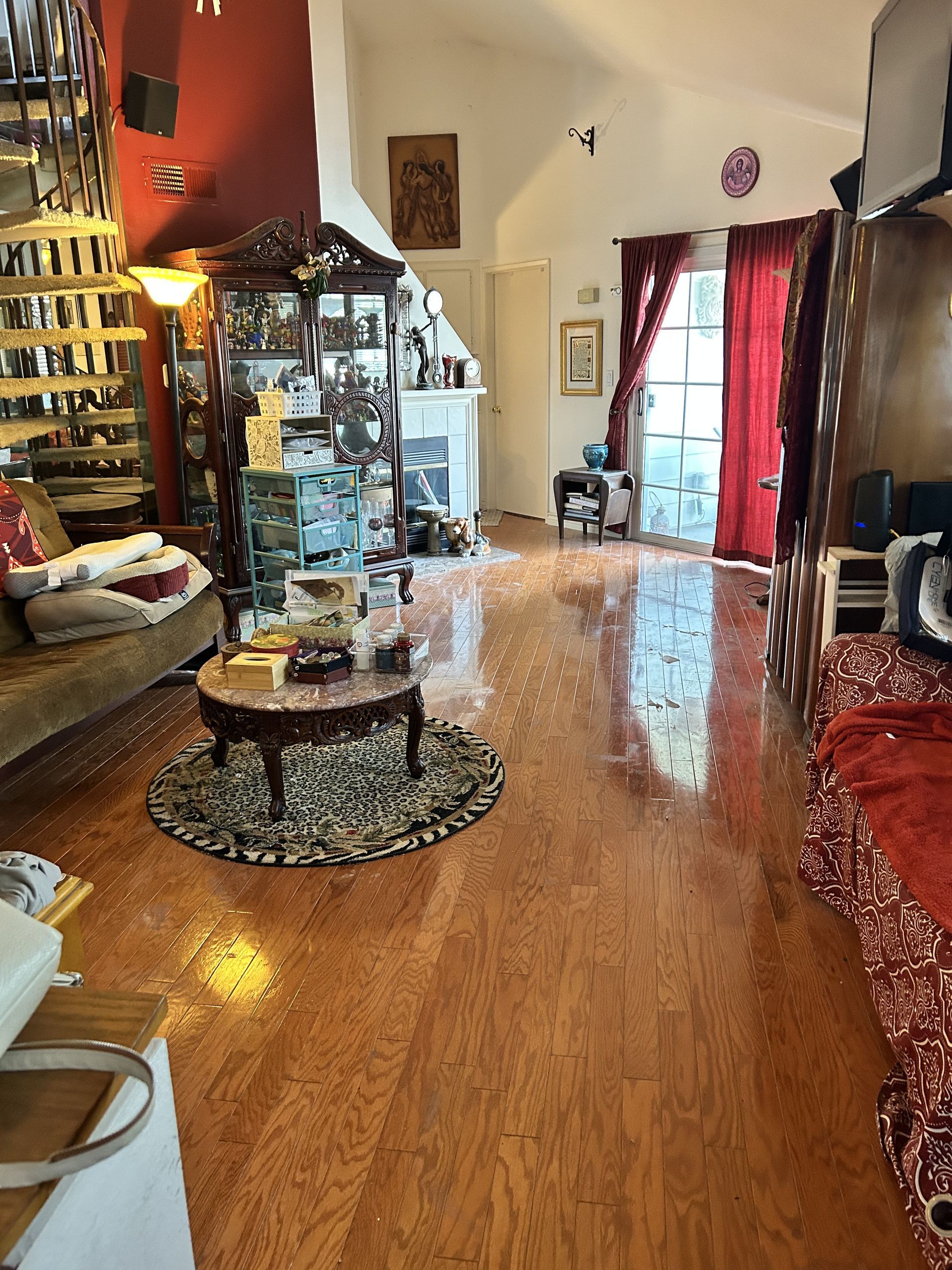 A living room with hardwood floors , a couch , a table , and a rug.