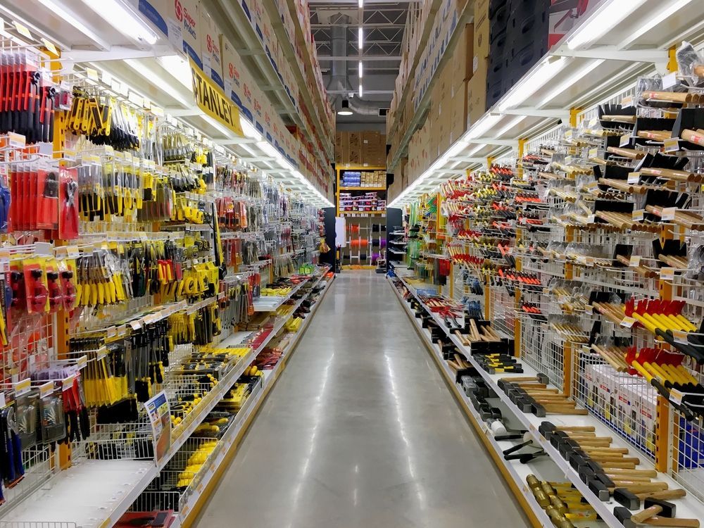 a long aisle of a hardware store filled with lots of tools .