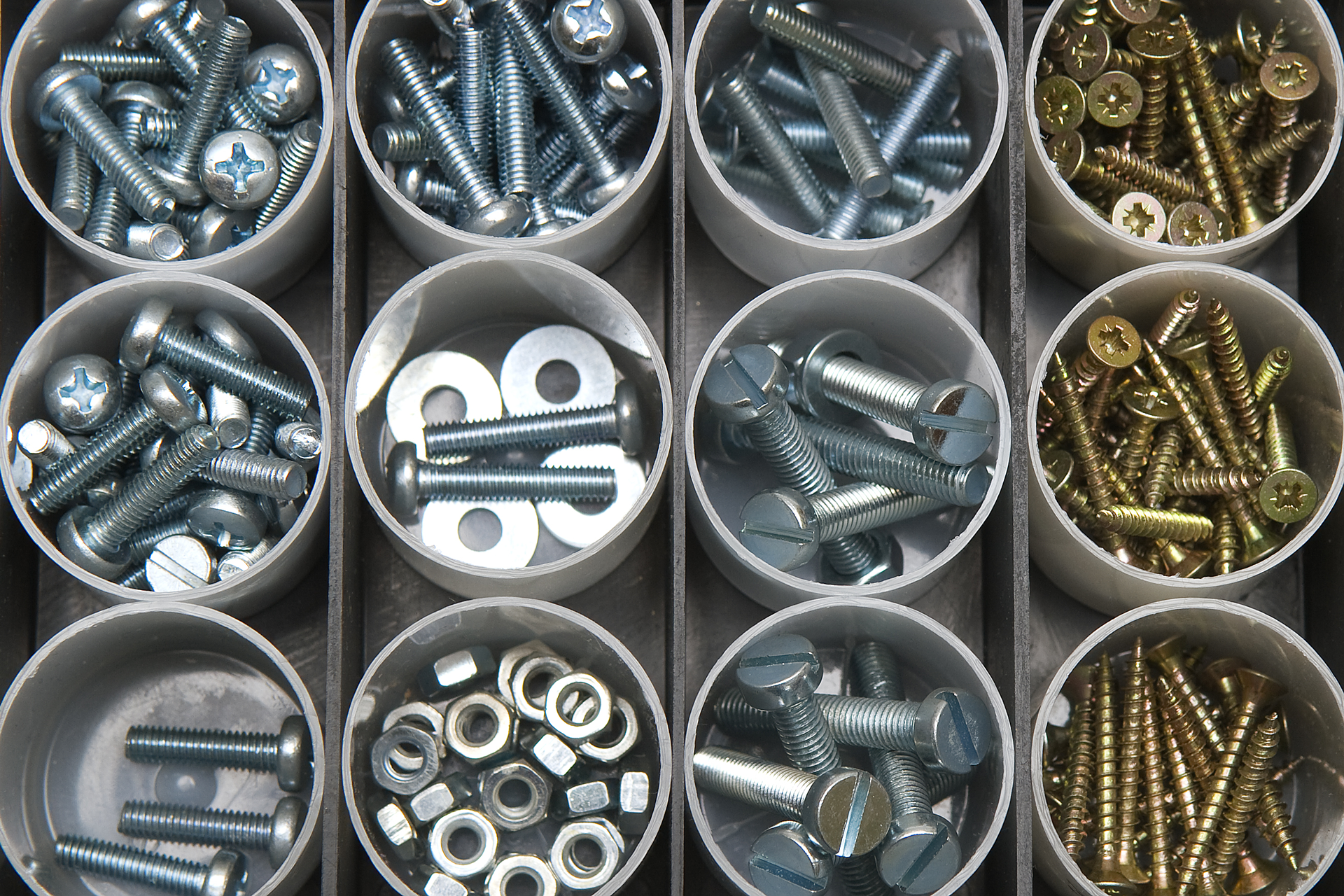 a variety of screws and washers in plastic containers