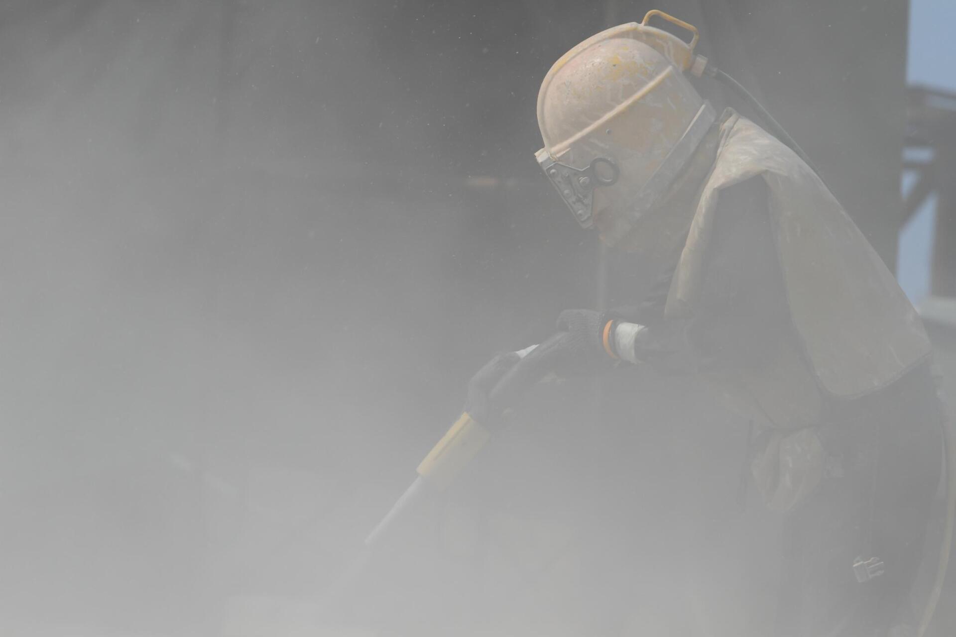 man working on an industrial sandblasting