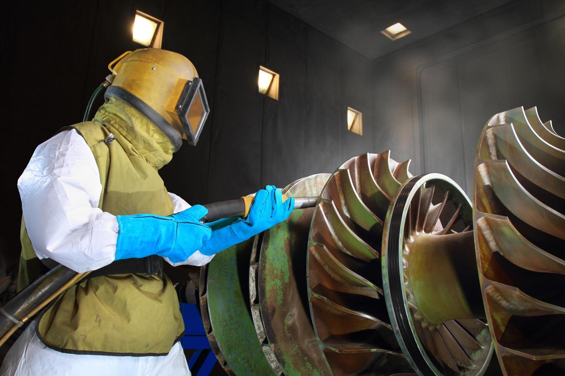 man working on a sandblasting machine