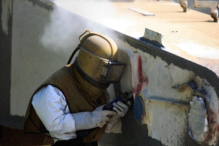 man with a helmet doing sandblasting