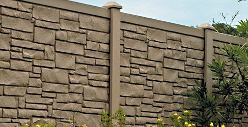 Stone-textured concrete fence in brown tones, with posts and capstones.