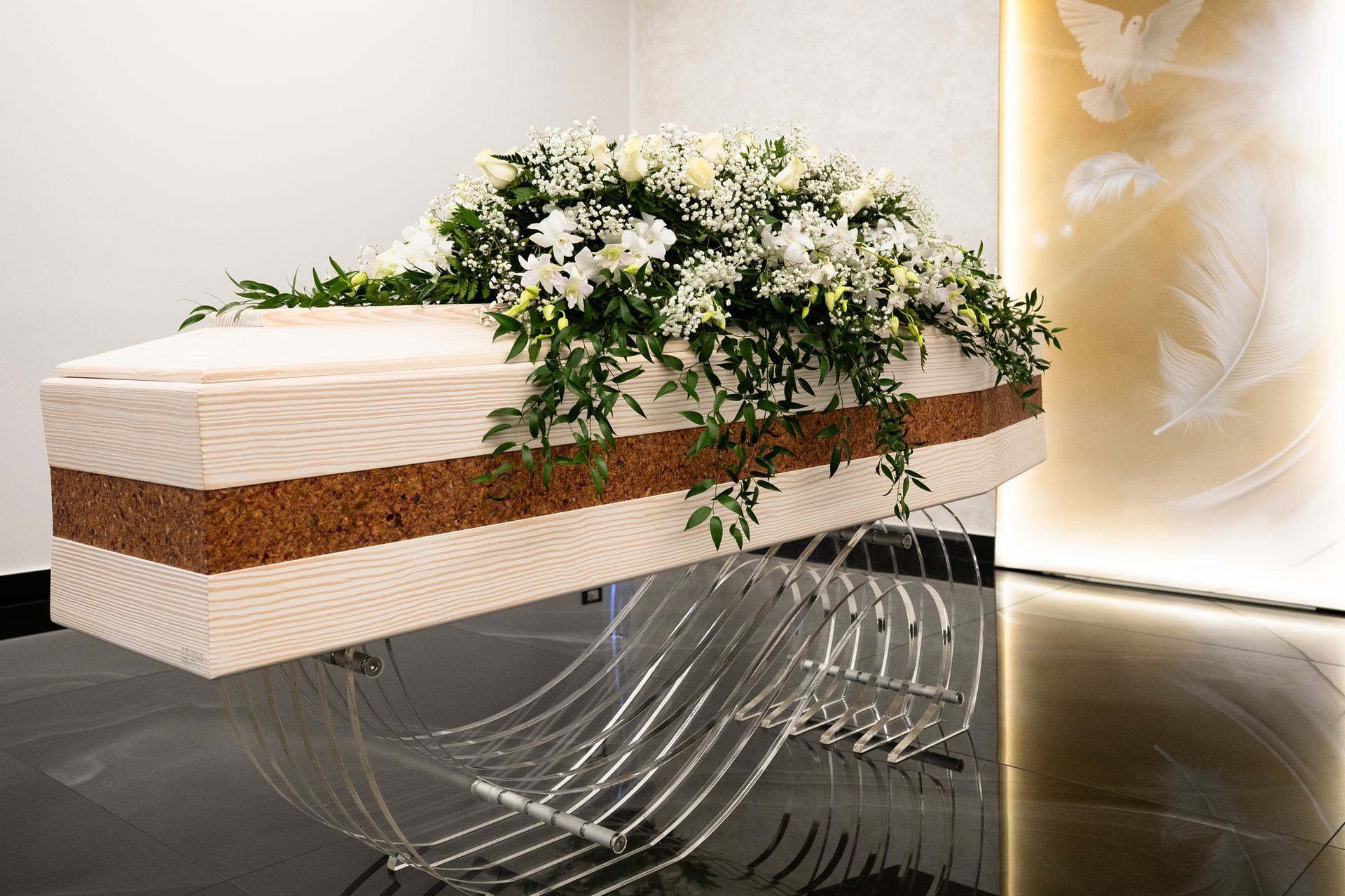 Bara di legno chiaro adornata con fiori bianchi su un supporto decorativo, in una stanza luminosa.