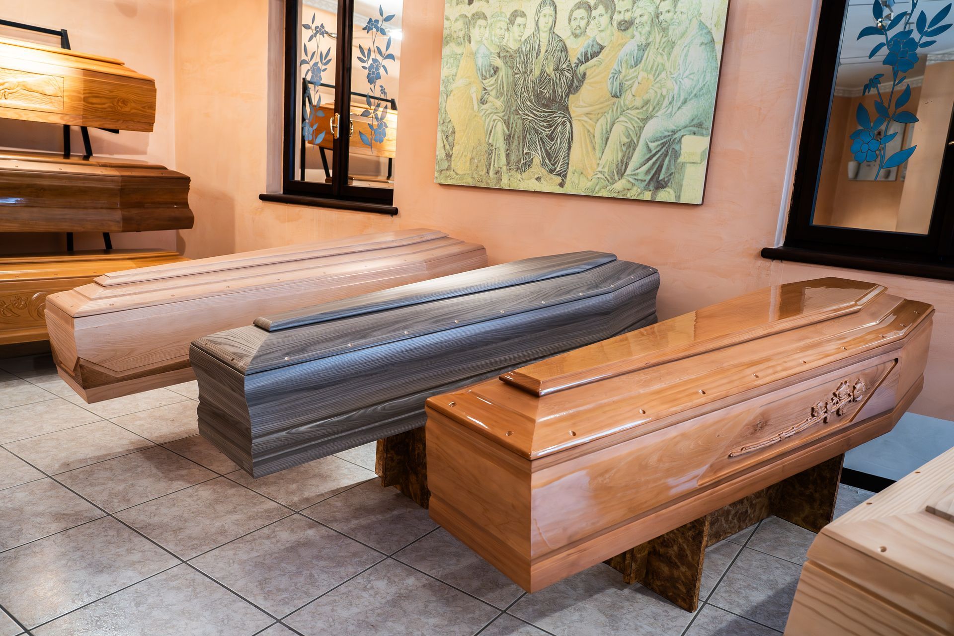 Bare di diverse tonalità di legno esposte in uno showroom ben illuminato con opere d'arte decorative alle pareti.