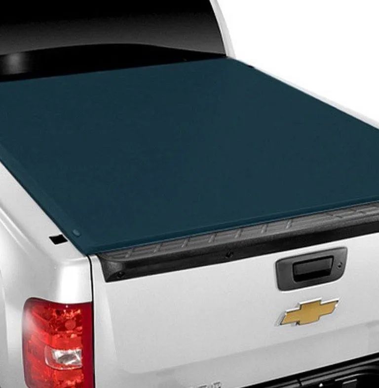 A blue tonneau cover on a white Chevrolet pickup truck bed.