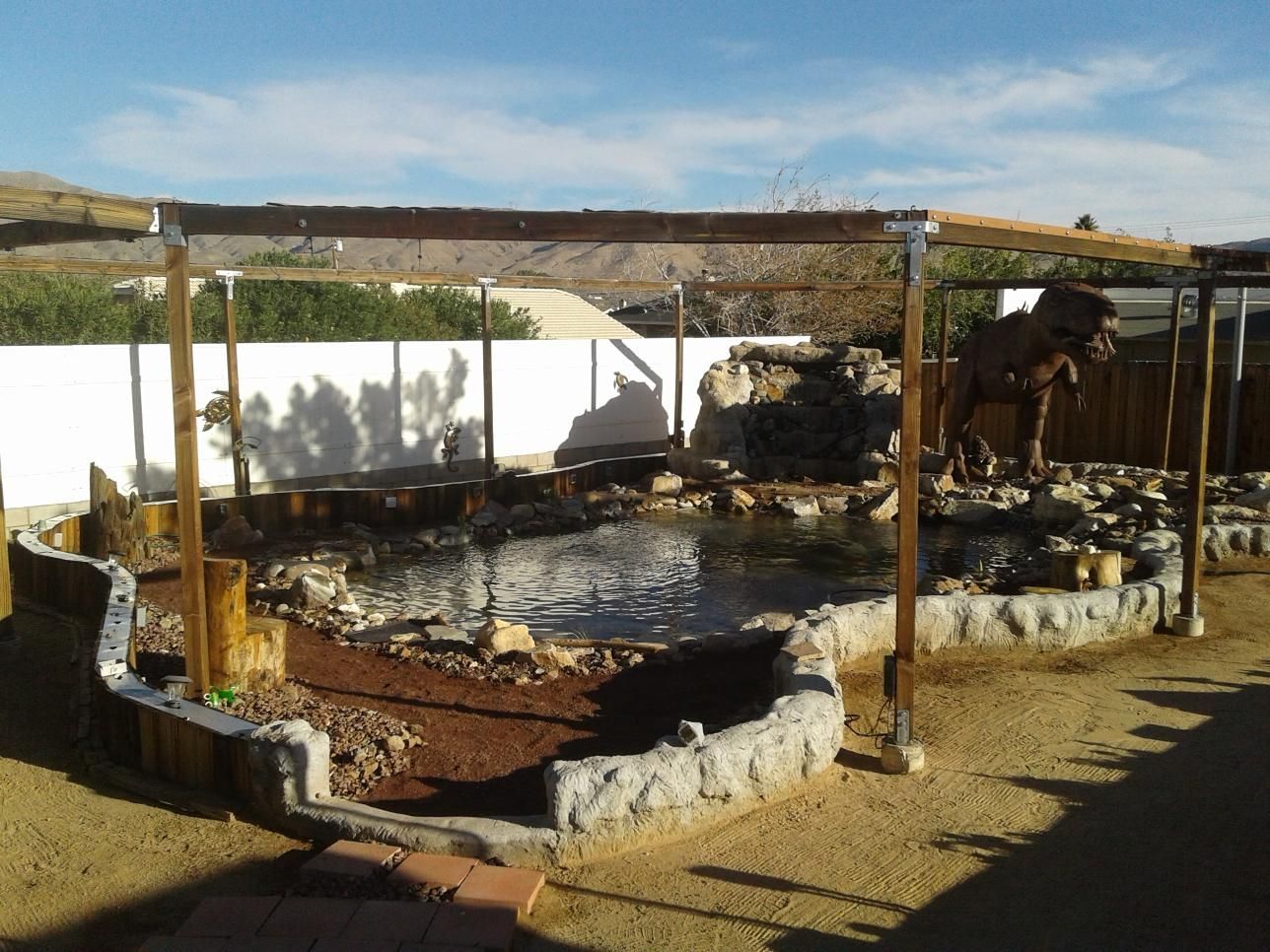 A large pond surrounded by rocks and a wooden structure