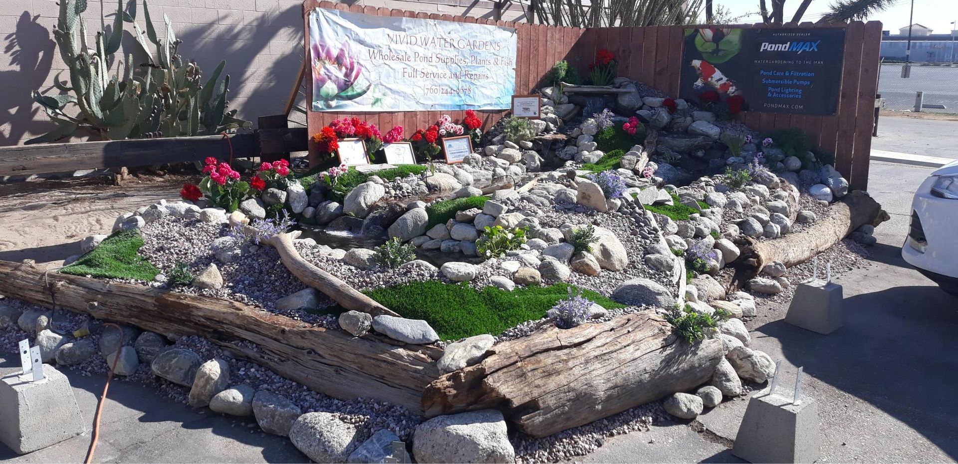 A white car is parked in front of a rock garden