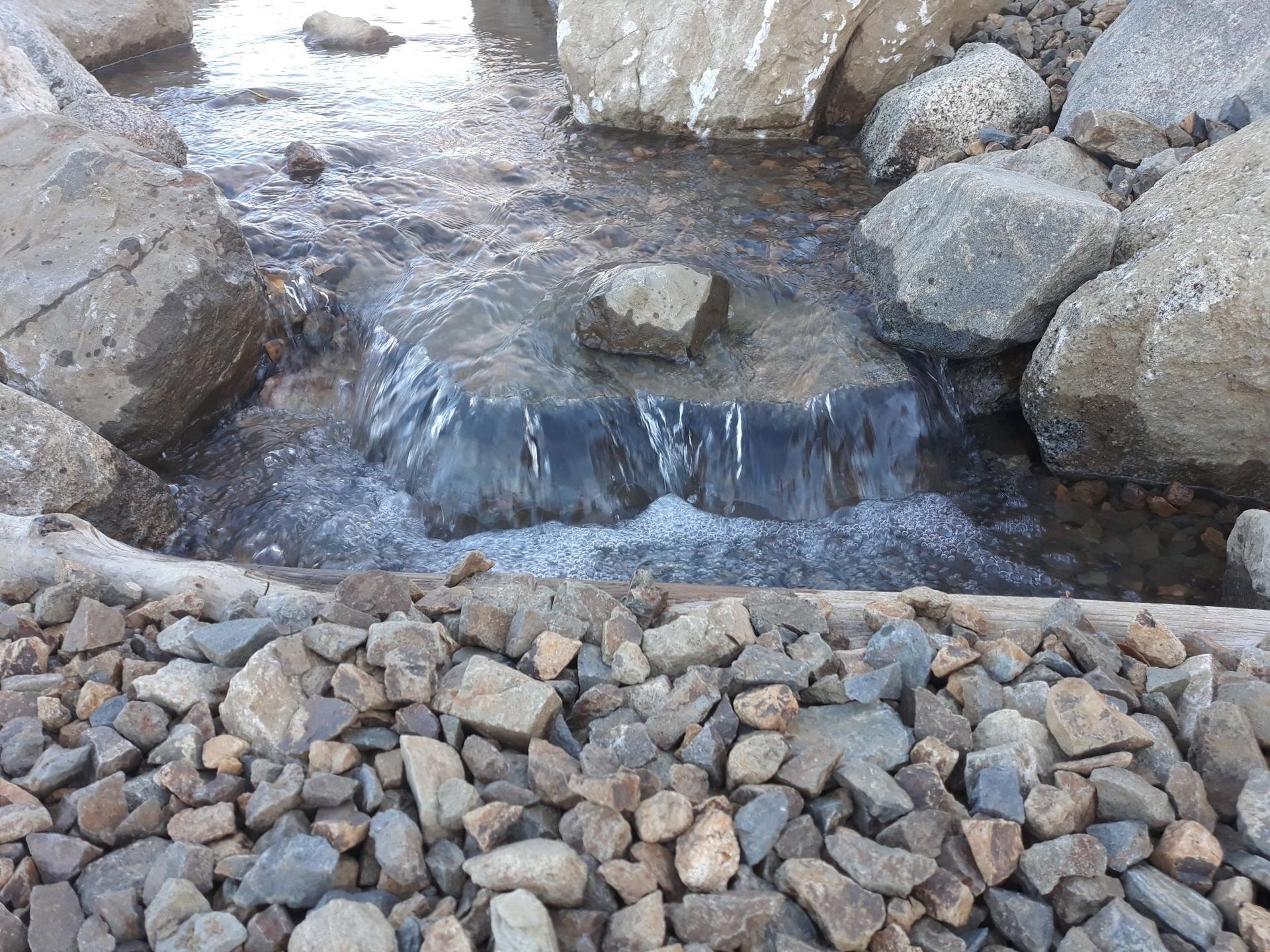A stream of water is flowing through a pile of rocks.