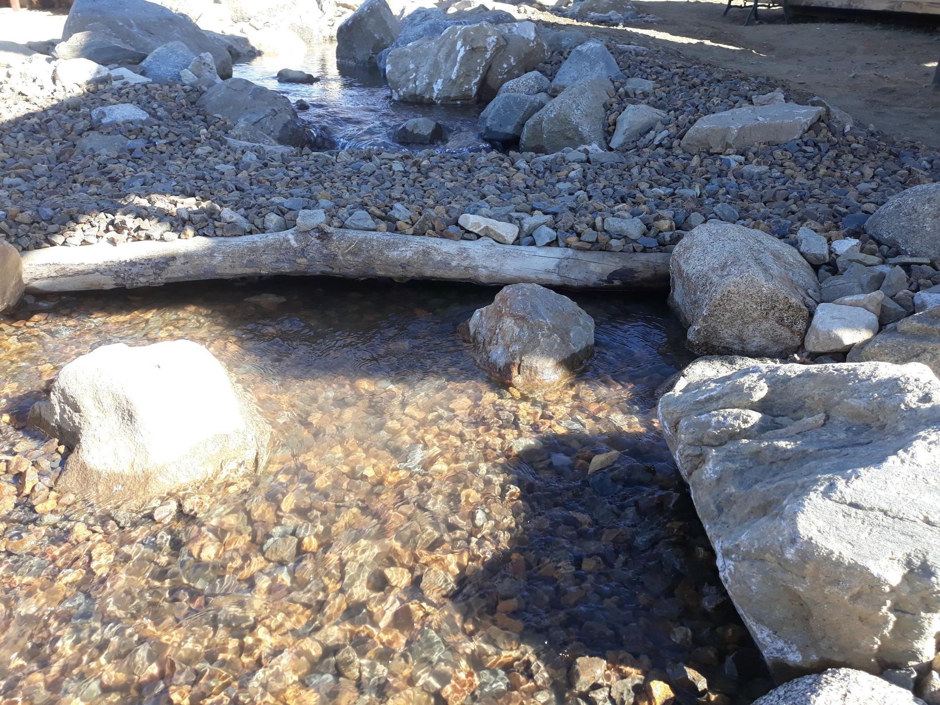 A stream of water surrounded by rocks and gravel