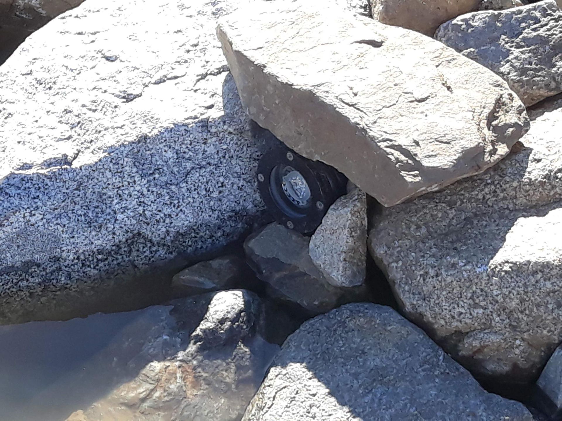 A tire is sitting on top of a pile of rocks