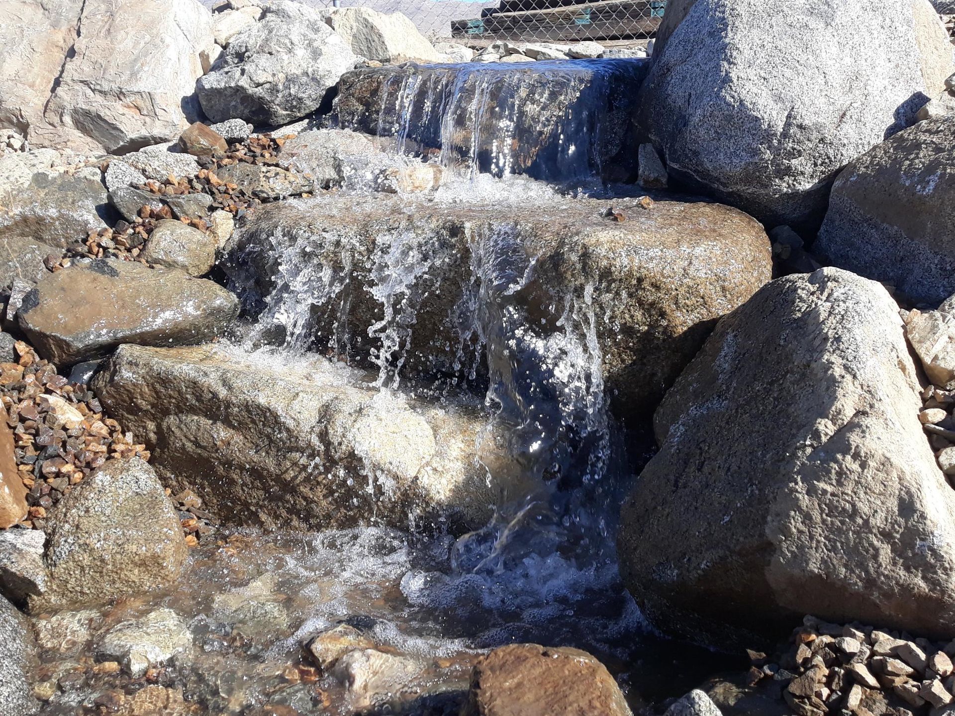 A small waterfall is surrounded by large rocks