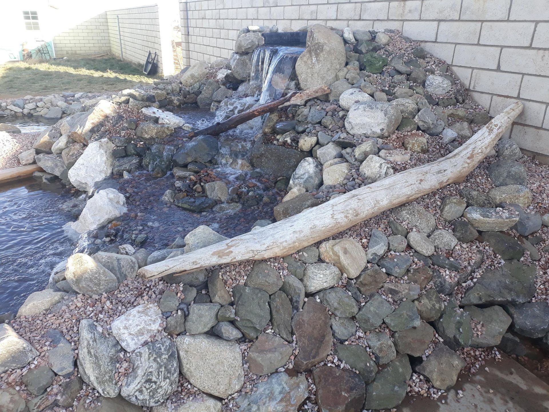 A pile of rocks with a waterfall in the background.