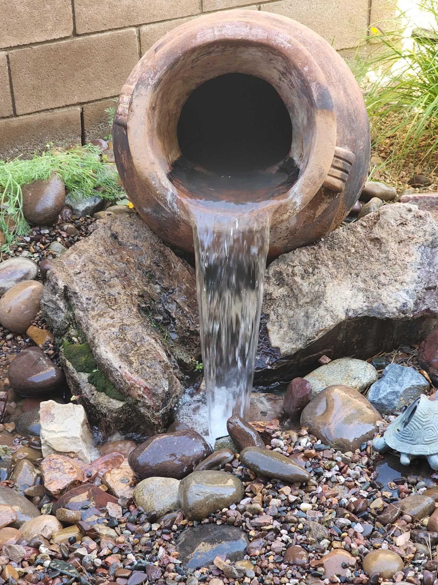 A waterfall is being poured out of a clay pot.