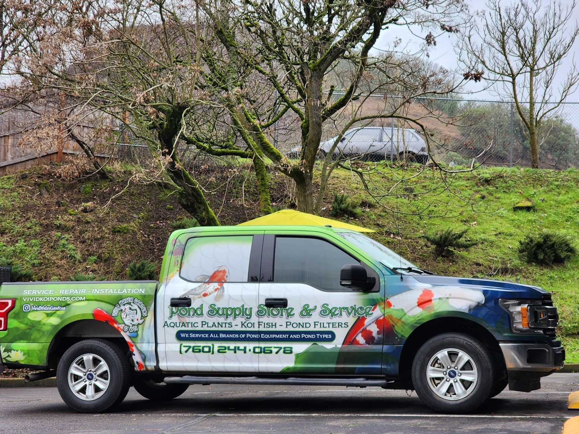 A truck is parked in a parking lot with trees in the background.