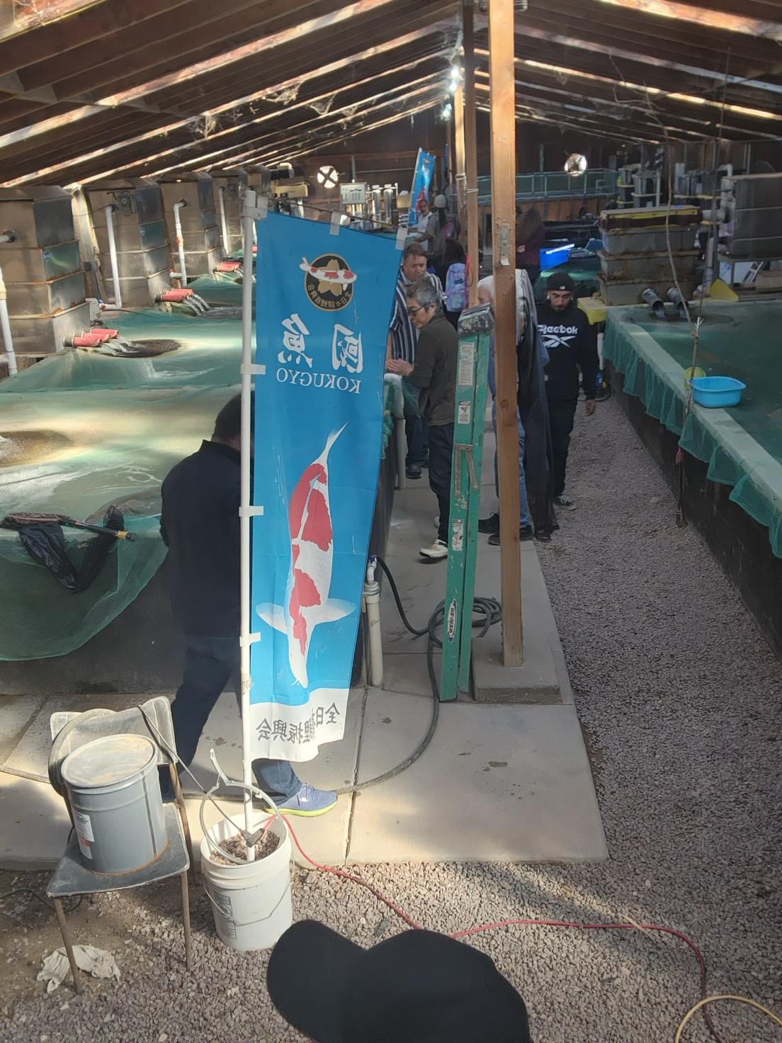 A group of people are standing in a room with a blue flag in the foreground.