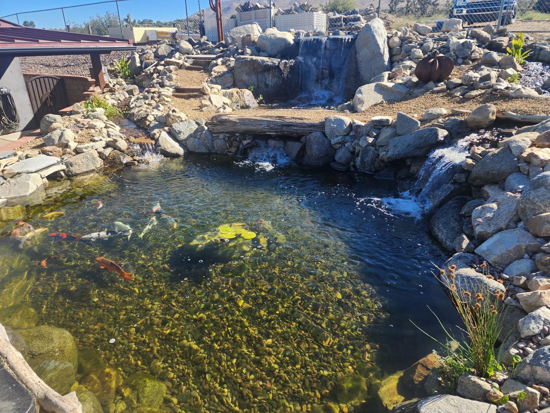 A large pond surrounded by rocks and a waterfall.
