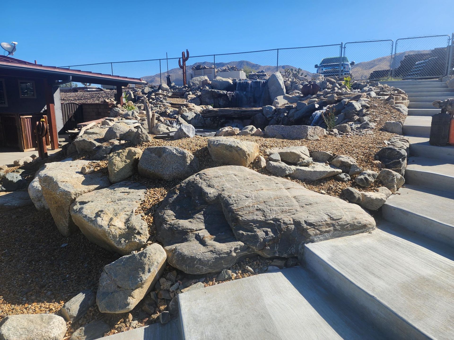 A rocky area with stairs and a building in the background