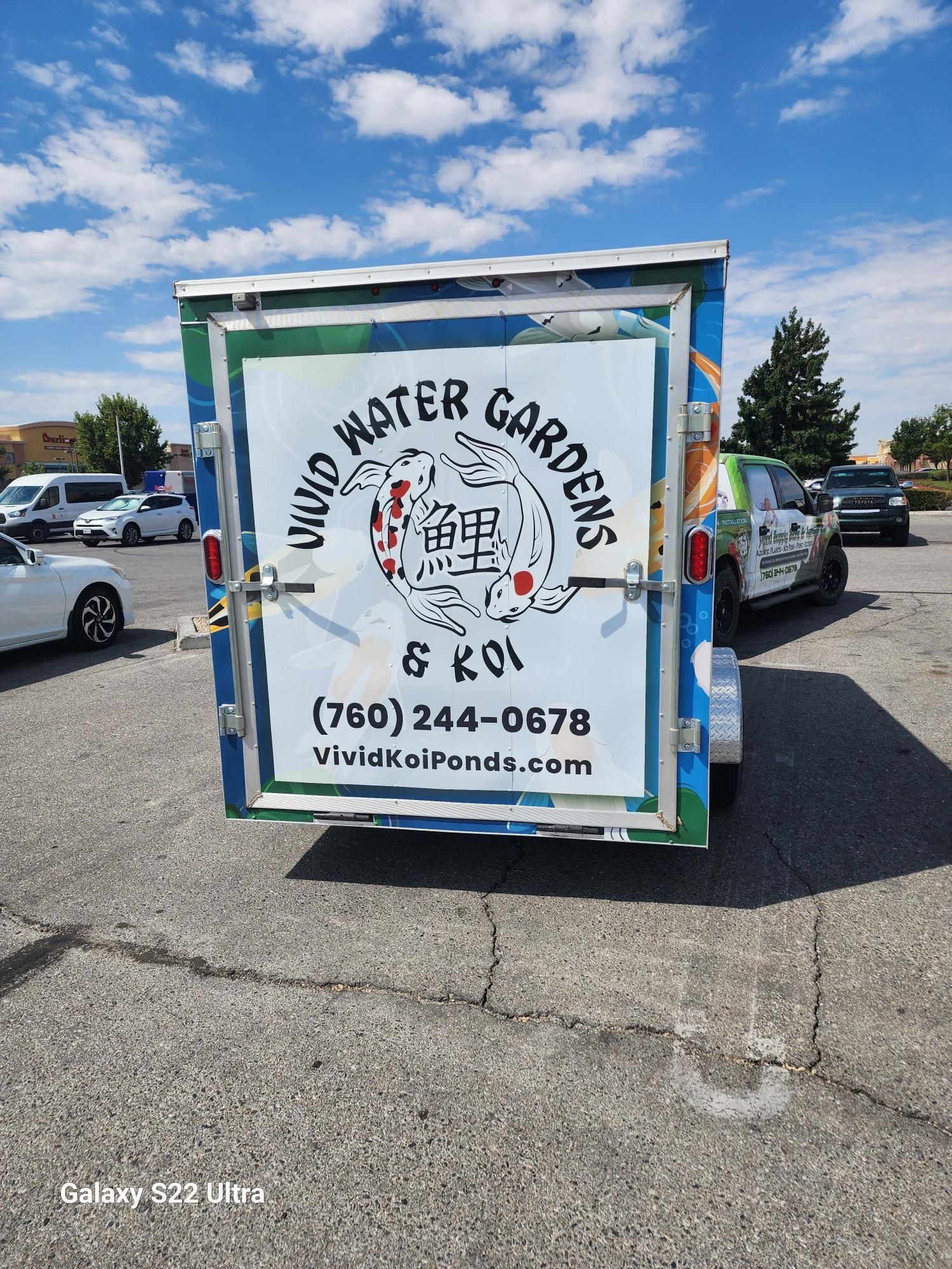 A trailer with a sign on it that says vivid water gardens is parked in a parking lot.