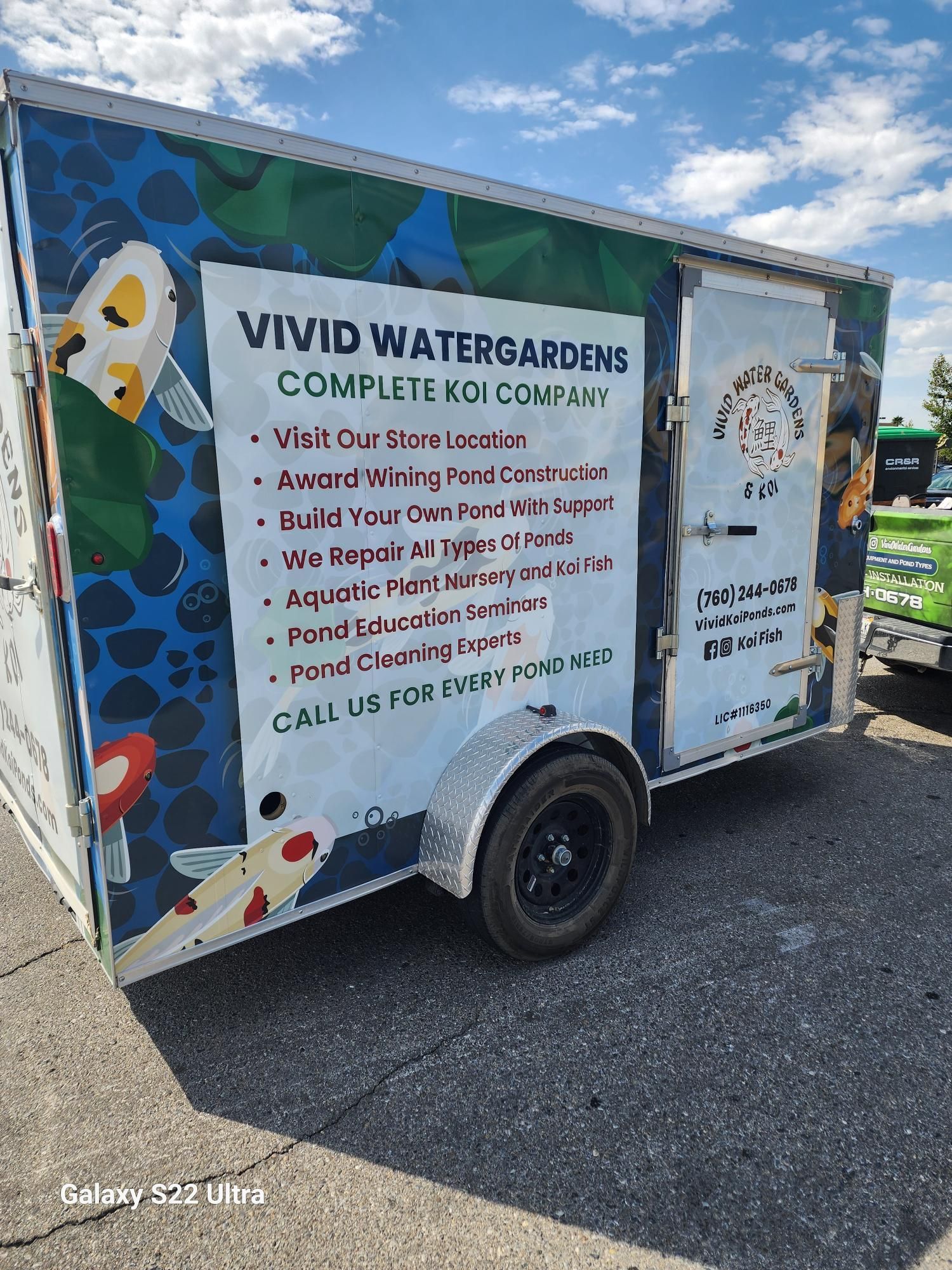 A trailer for vivid watergardens is parked on the side of the road.
