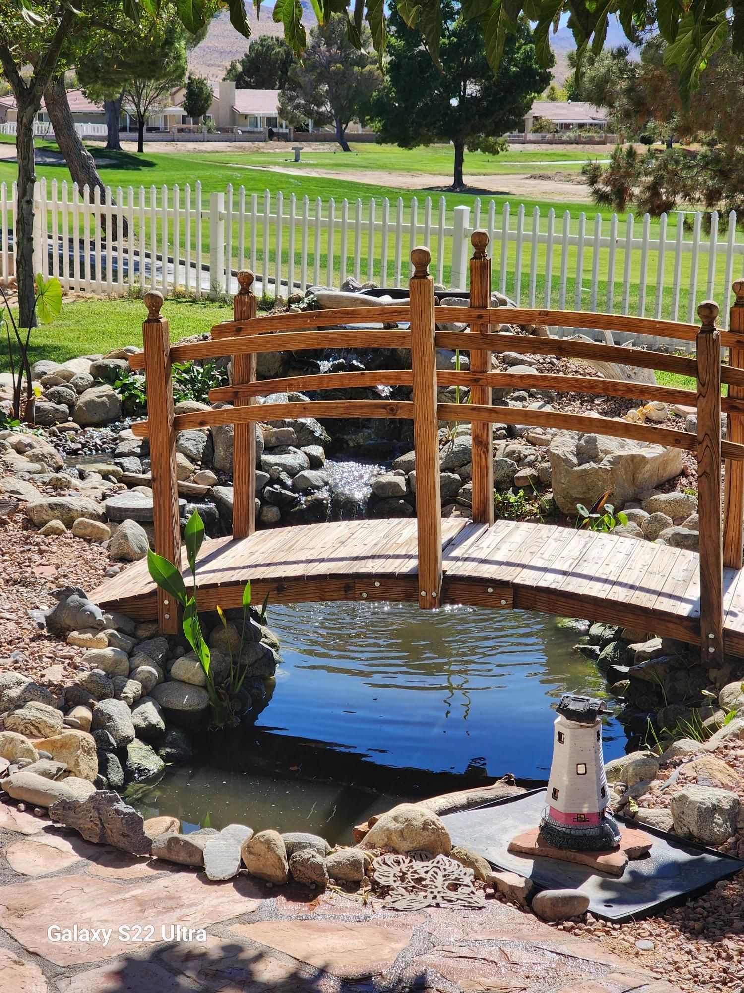 A small wooden bridge over a pond in a park