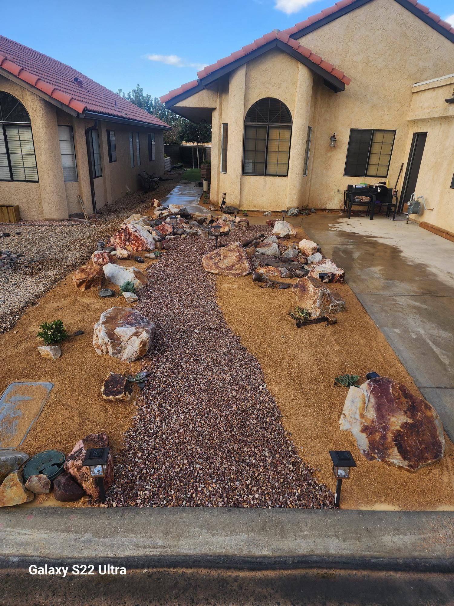 A house with a rock garden in front of it.