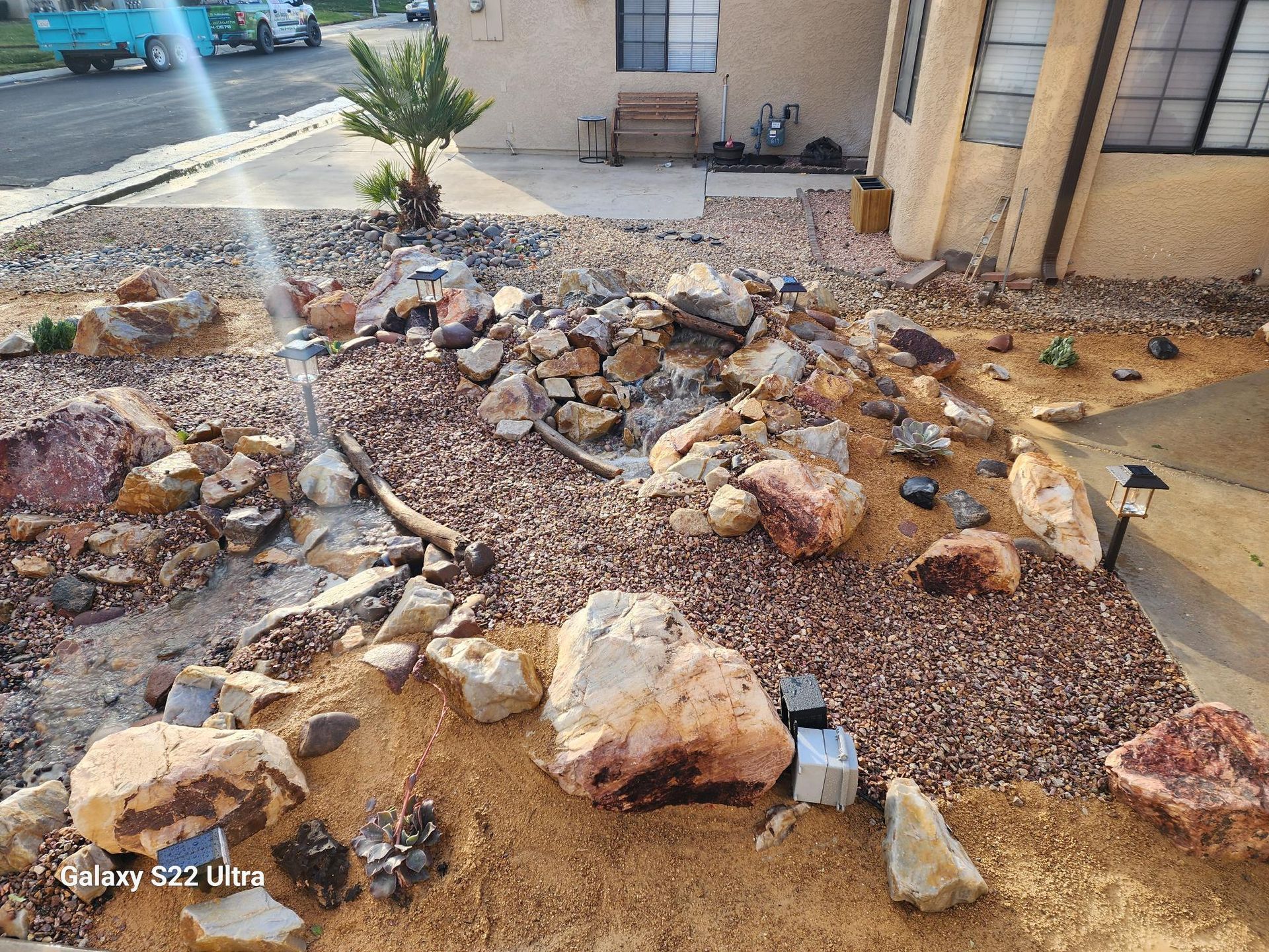 A garden with rocks and dirt in front of a house.