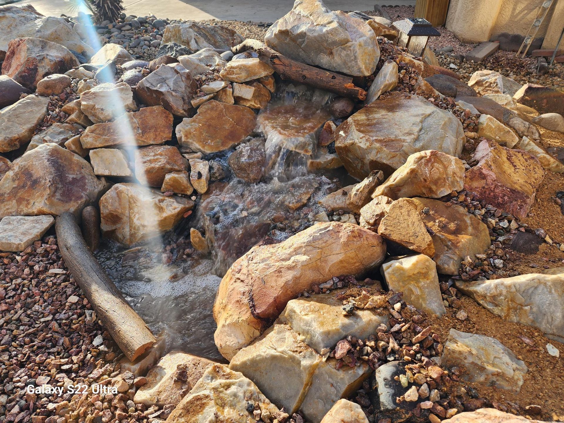 There is a waterfall in the middle of a pile of rocks.