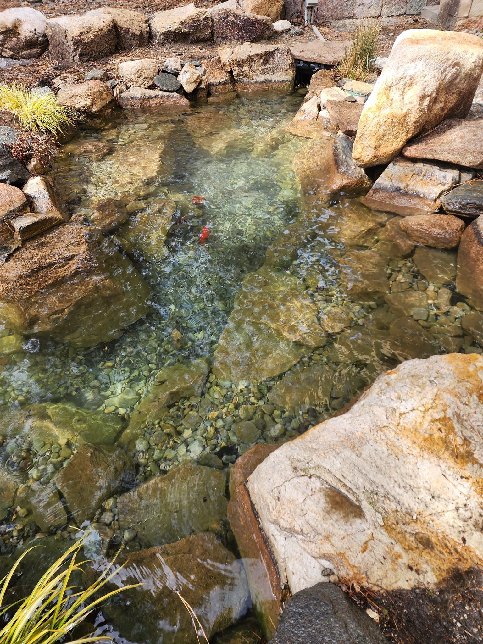 A pond filled with rocks and water surrounded by rocks.