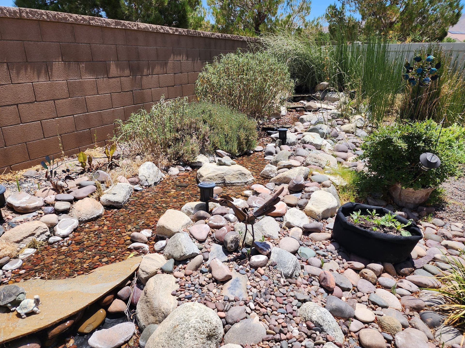 A rock garden with a brick wall in the background