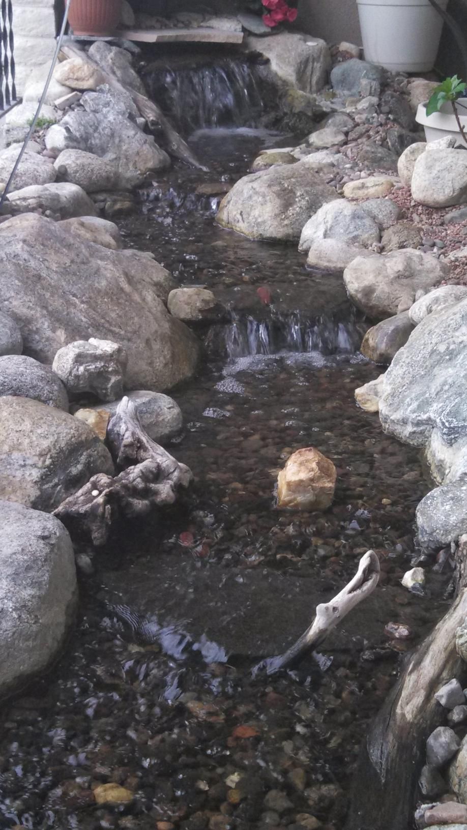 There is a small waterfall in the middle of a rocky area.