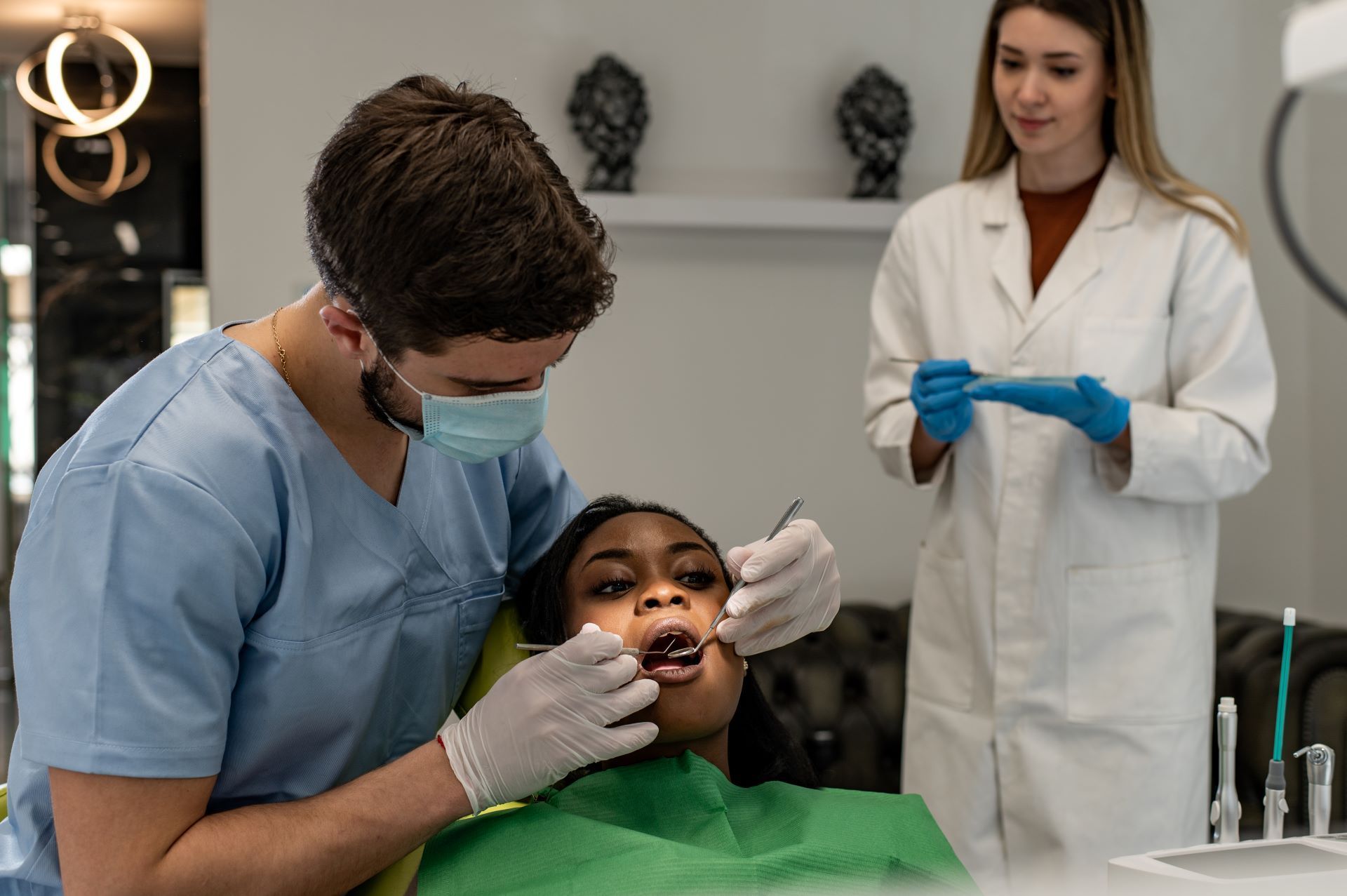 A dentist is examining a patient 's teeth in a dental office.