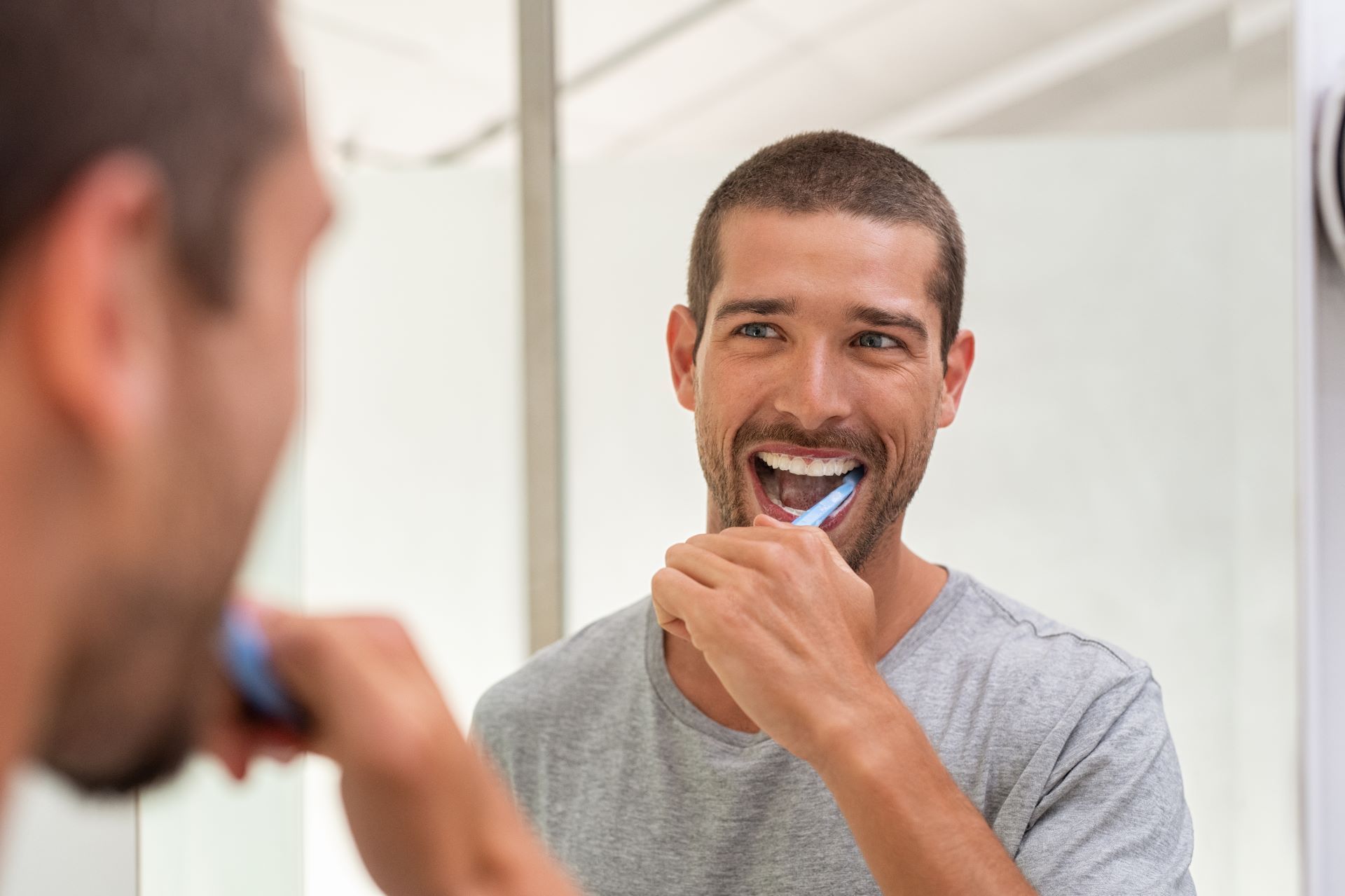 man happy brushing his teeth