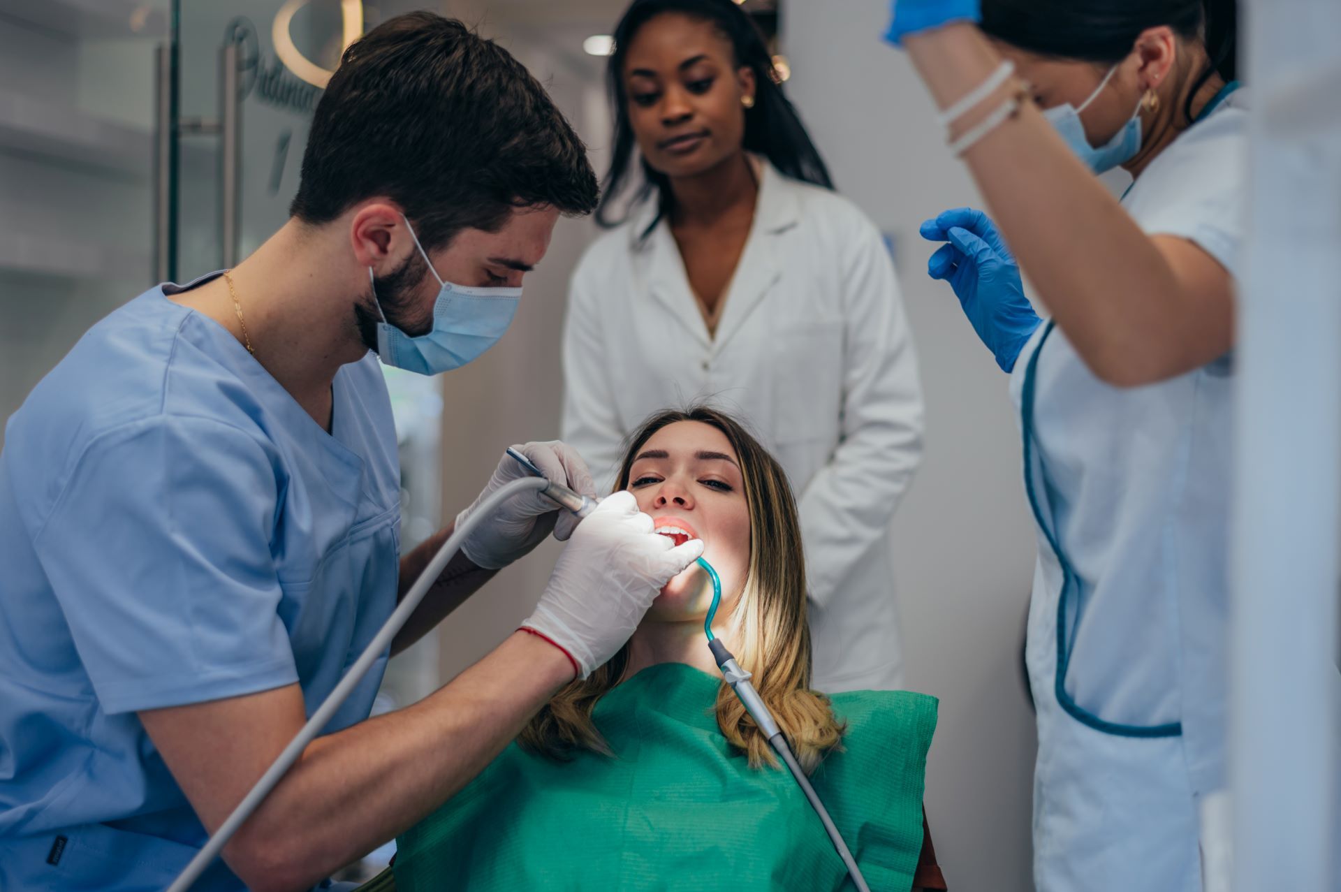 A dentist is examining a patient 's teeth in a dental office.