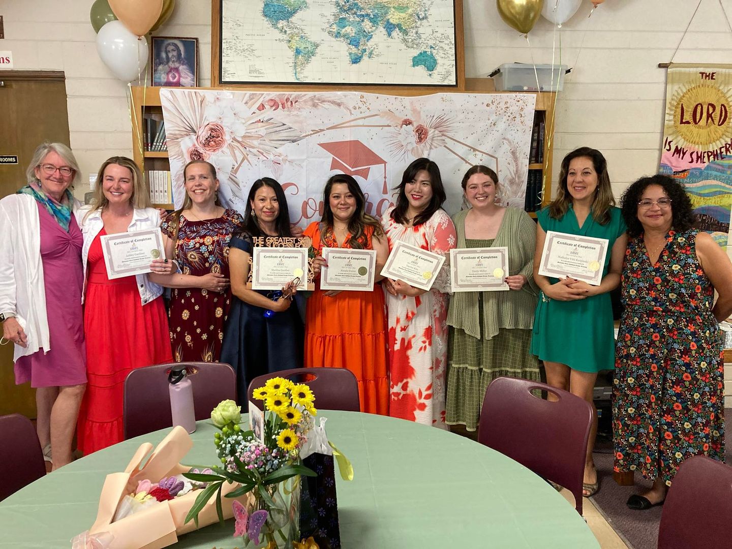 A group of adult learners are posing for a picture with their diplomas