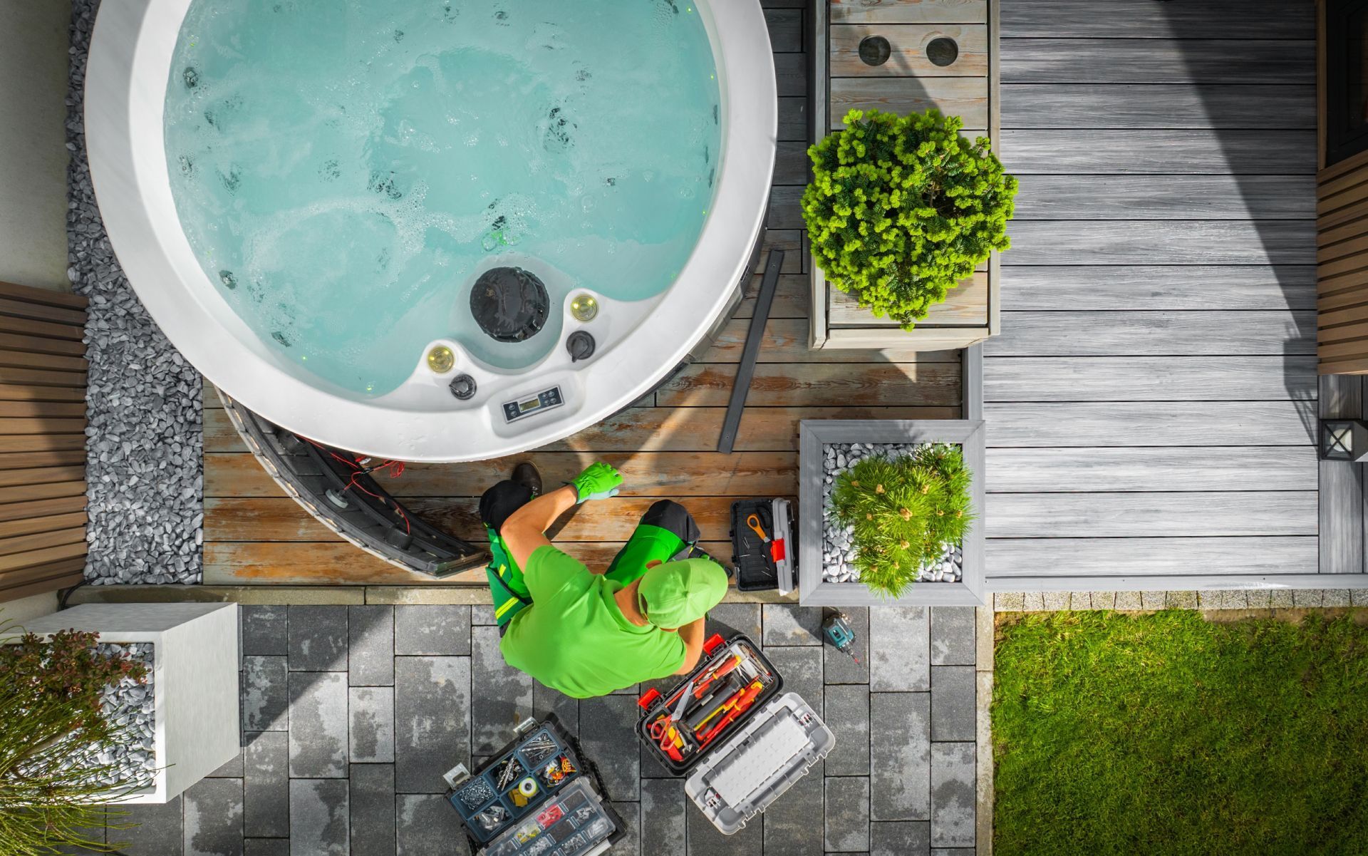 An aerial view of a man working on a hot tub.