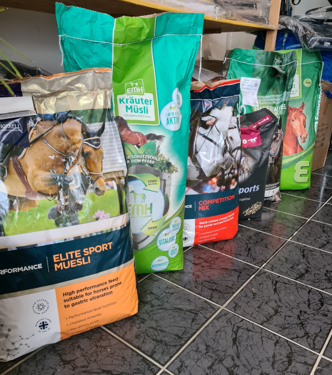 Mehrere Säcke mit Pferdefutter sind auf einem gefliesten Boden aufgereiht