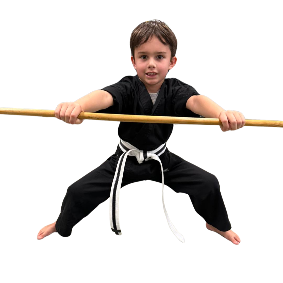 A boy and two girls are wearing karate uniforms and pointing at the camera