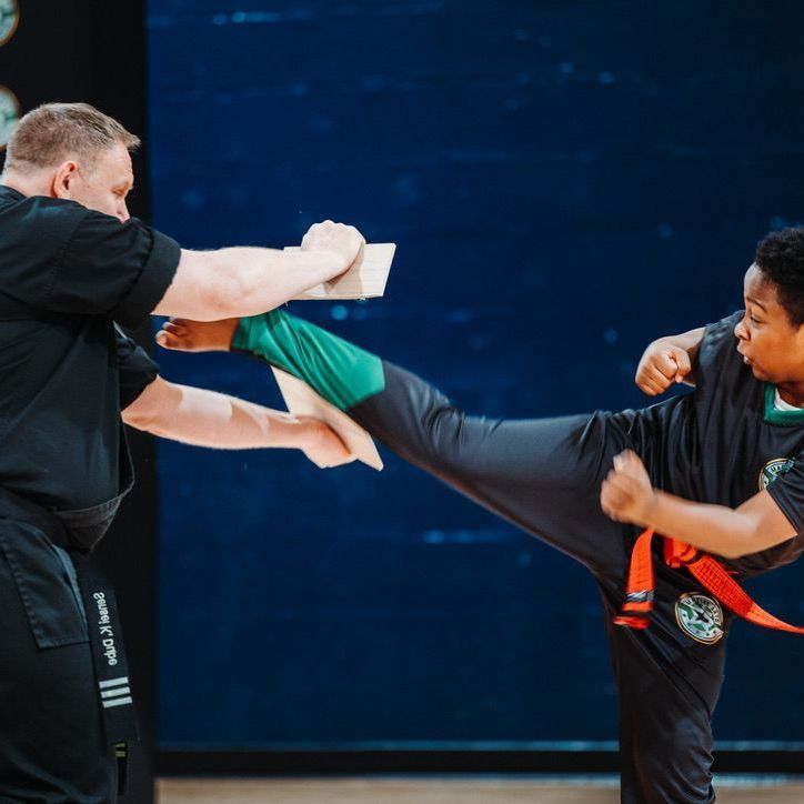 A boy and a girl are practicing taekwondo together.