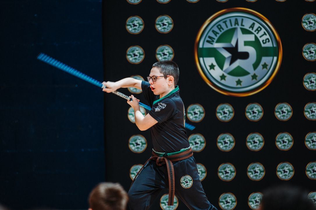 A person is holding a sparkler in their hand in the dark.