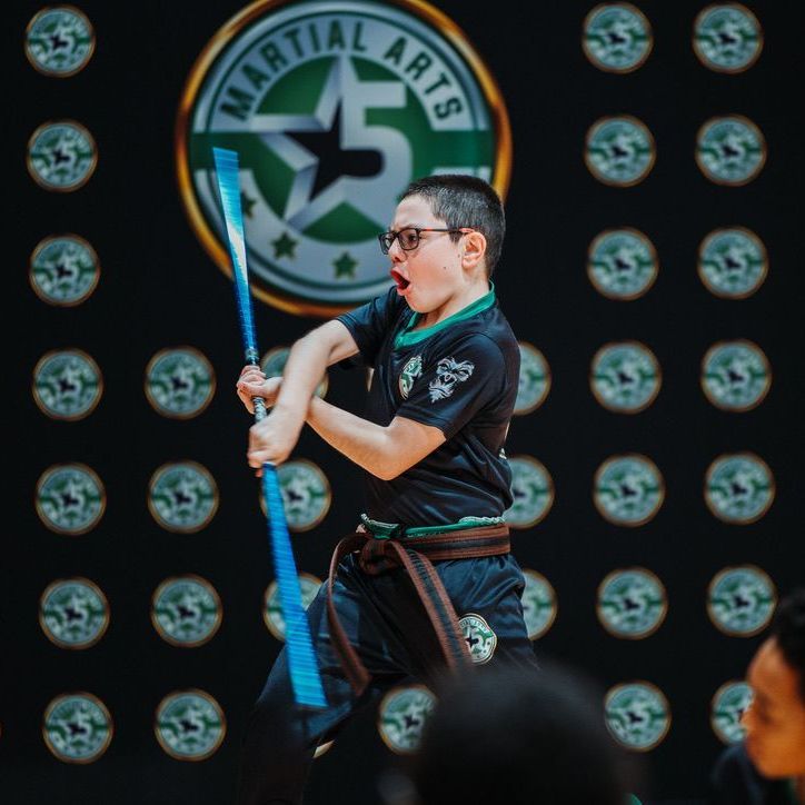 A group of men are practicing karate in a gym.