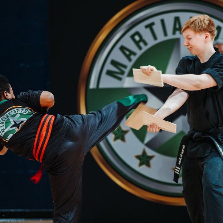 Two young men are practicing karate on a mat