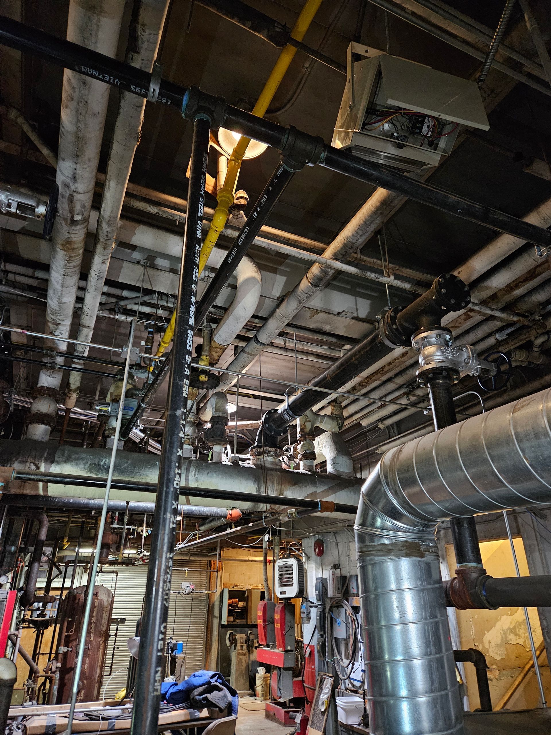 A room with a lot of pipes hanging from the ceiling.