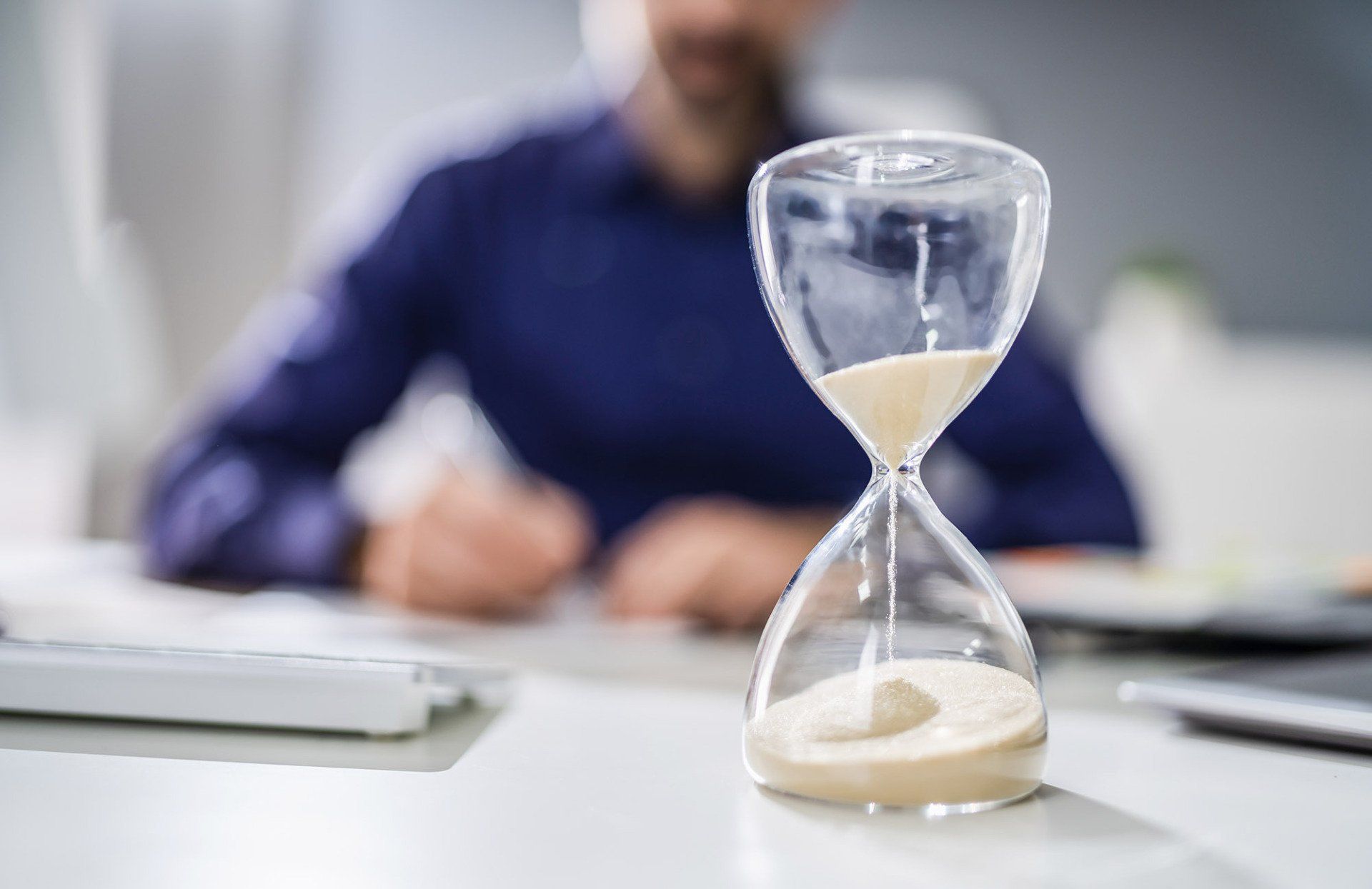 Man at a desk with an hourglass timer