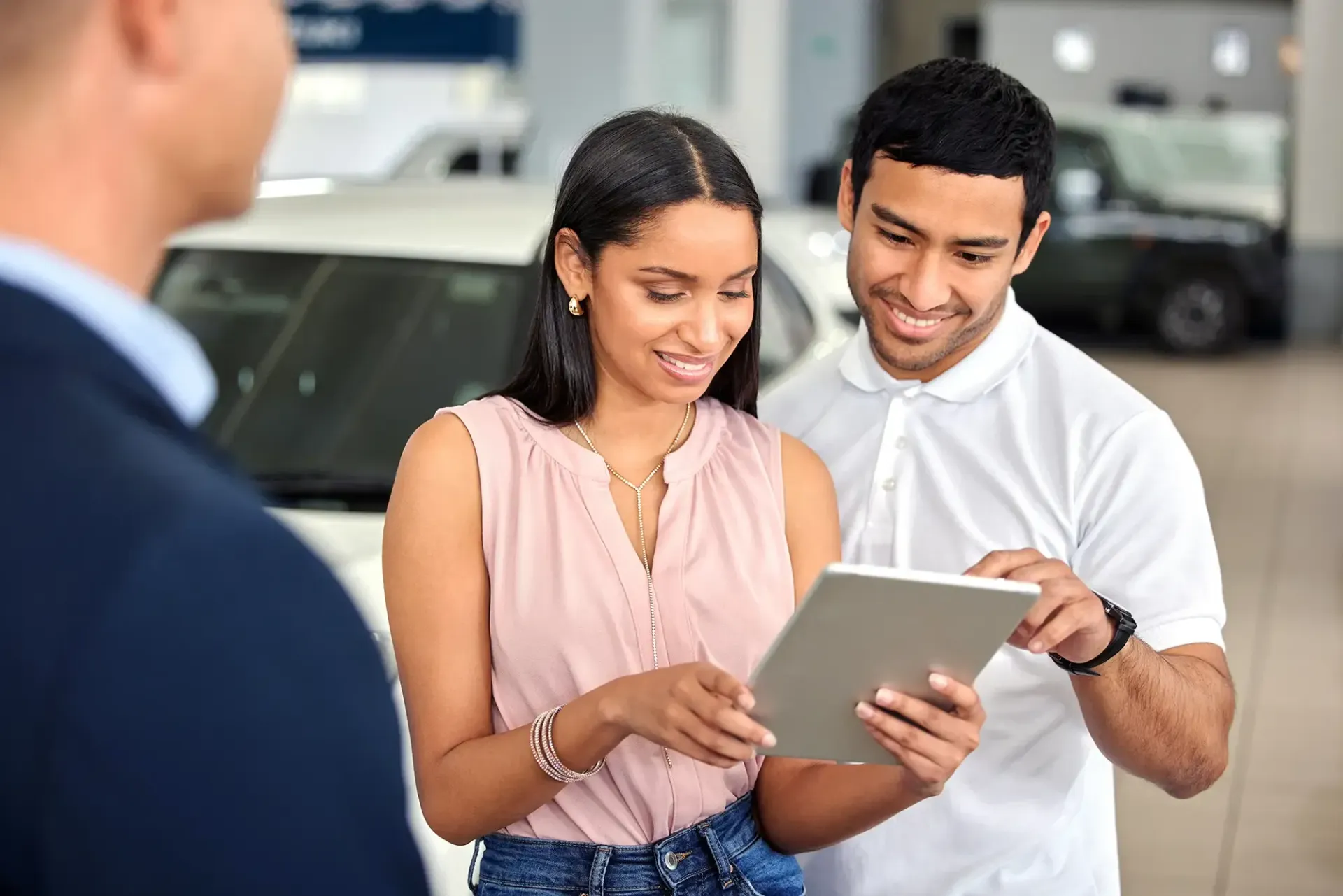 Man and a Woman looking at cars on a tablet. 