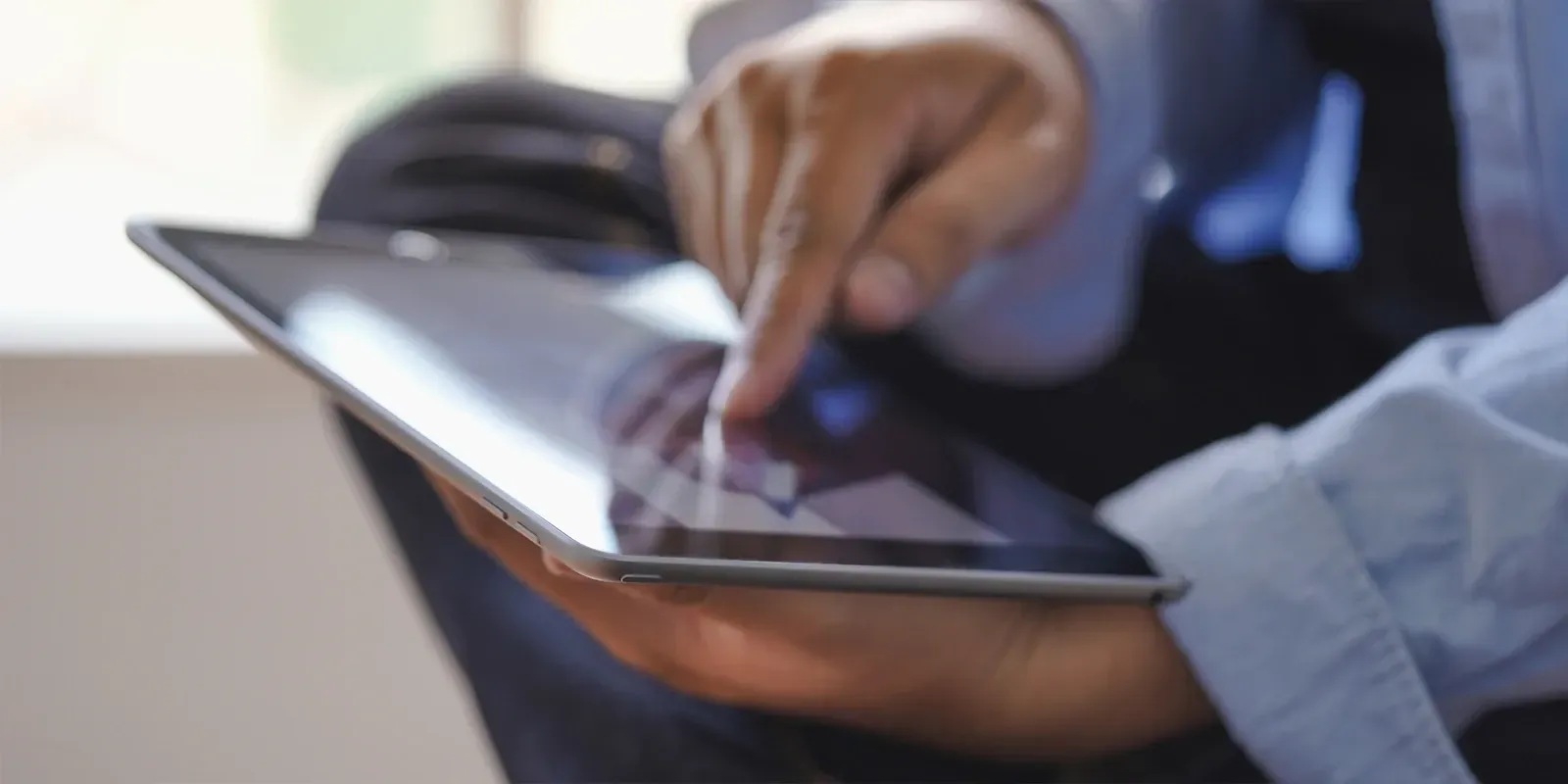 Person touching a tablet screen with one finger.