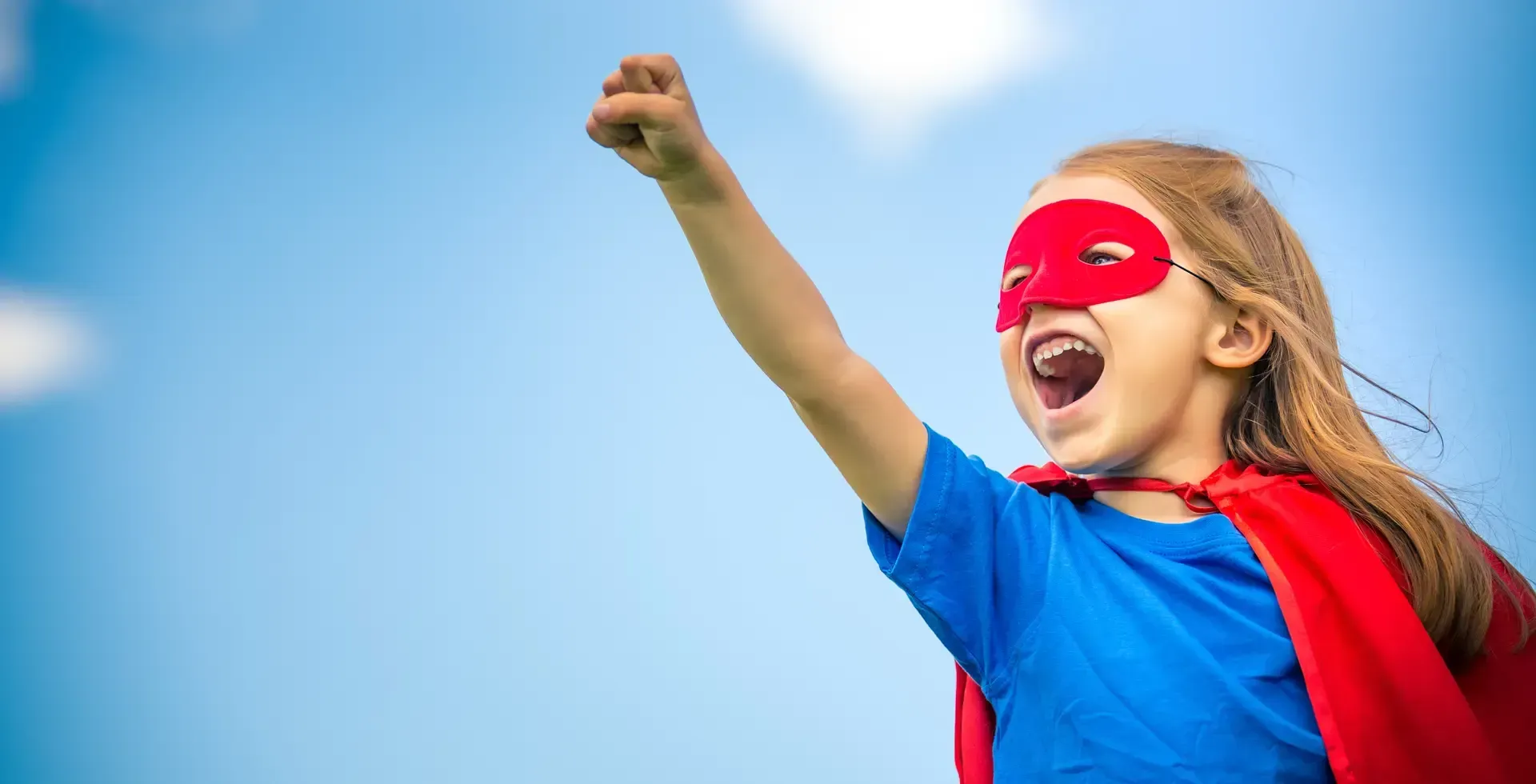 little girl playing super hero wearing a cape