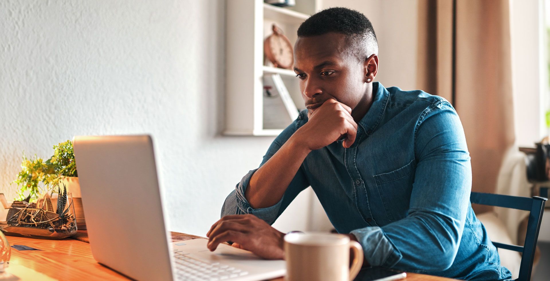 man looking at laptop thinking